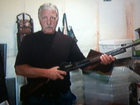 Greg Kvisle is shown in a television framegrab from Sun News in High River, Alta August 8, 2013.  He is shown with his guns that were seized by RCMP, despite his home not being in a flooded out area.  Edward Dawson/ Sun News/QMI Agency