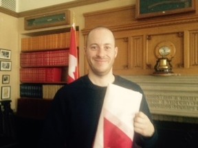 Robert Labonte is holding the flag he took down Thursday, Feb. 12, 2015. SUSAN SHERRING/OTTAWA SUN