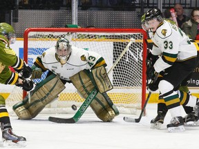 London Knights goalie Michael Giugovaz keeps his eyes on the puck as North Bay Battalion defenceman Austin Kosack (2) passes to a teammate held back by defenceman Julius Bergman (33) during second period OHL action at Memorial Gardens in North Bay, Thursday. The Battalion won 5-2. (Dave Dale, QMI Agency)