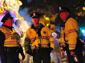 A float passes officers of the New Orleans Police Department, deployed as part of security measures at the Mardi Gras parade in New Orleans, Louisiana February 12, 2015. According to local media, two persons were shot during Thursday night's parade on St. Charles Avenue. One male suspect is in custody, and the victims have been taken to the hospital. (REUTERS/Jonathan Bachman)