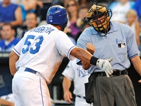 Melky Cabrera (left) argues the strike zone with home plate umpire Dale Scott during MLB action in Kansas City in 2011. The league is considering shrinking the strike zone to help increase more offence, according to a report. (Dave Kaup/Reuters/Files)