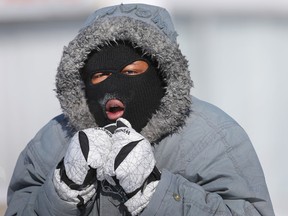 Jesse Ferrara tries to keep warm on his walk home on St. Laurent Blvd after work on Friday Feb 13, 2015. Temperatures reached as low as -40 with the windchill in Ottawa Friday.  
Tony Caldwell/Ottawa Sun/QMI Agency