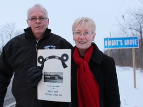 Carol Ryan, pictured with her husband Mike, is a descendent of Robert and Jim Bright, who settled in the Bright's Grove community in the mid-1800s. She says the apostrophe belongs in the spelling of the community's name. She's pictured holding a centennial year book for Bright's Grove school. (TYLER KULA/QMI AGENCY)