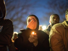 A woman cries as a video is played during a vigil on the campus of the University of North Carolina, for Deah Shaddy Barakat, his wife Yusor Mohammad and Yusor's sister Razan Mohammad Abu-Salha who were killed in Chapel Hill, North Carolina February 11, 2015. Gunman Stephen Hicks, who had posted anti-religious messages on Facebook and quarreled with neighbors, was charged with killing the three young Muslims in what police said on Wednesday was a dispute over parking and possibly a hate crime. REUTERS/Chris Keane
