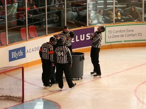 Officials inspect a leak in the TD Place roof after a broken pipe caused water to spray on the ice surface. The game was delayed by an hour as a result of the leak. (Chris Hofley/Ottawa Sun)