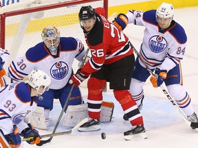 Feb 9, 2015; Newark, NJ, USA; Edmonton Oilers goalie Ben Scrivens (30) looks for the puck while New Jersey Devils left wing Patrik Elias (26) and Edmonton Oilers defenseman Oscar Klefbom (84) battle during the third period at Prudential Center. The Oilers defeated the Devils 2-1.  Mandatory Credit: Ed Mulholland-USA TODAY Sports