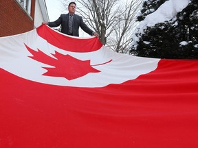 Bryson Kuno poses with his Canadian flag outside his home on Thursday Feb 12, 2015. Bryson was on a waiting list for 12 years to receive a flag which flew from the Peace Tower on Parliament Hill.  
Tony Caldwell/Ottawa Sun/QMI Agency