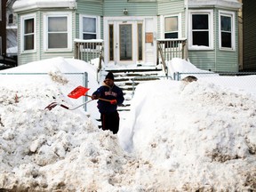 Aaron Bray, who came out to help clear snow around busy school routes at the request of the activist group Black Lives Matter Boston, shovels a sidewalk in Boston, Feb. 10, 2015. (BRIAN SNYDER/Reuters)