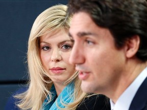 Member of Parliament Eve Adams, left, listens to Liberal leader Justin Trudeau speak during a news conference in Ottawa February 9, 2015. (REUTERS/Chris Wattie)