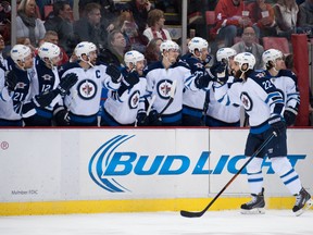 Chris Thorburn & the Jets celebrate a goal on the Red Wings on Saturday night. (TIM FULLER/USA Today Sports)