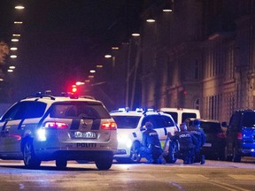 Police personnel and vehicles are seen along a street in central Copenhagen, early Feb. 15, 2015 following shootings at a synagogue in Krystalgade. One person was shot in the head and two police were wounded in an attack on the synagogue in central Copenhagen, Danish police said.  REUTERS/Martin Sylvest/Scanpix Denmark