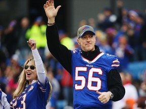 Former Buffalo Bills quarterback Jim Kelly, wearing the former jersey of Darryl Talley, acknowledges the crowd before the game against the Cleveland Browns at Ralph Wilson Stadium on November 30, 2014 in Orchard Park, New York.  (Tom Szczerbowski/Getty Images/AFP)
