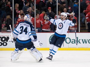 Winnipeg Jets goalie Michael Hutchinson (34) and Winnipeg Jets left wing Andrew Ladd (16) celebrate their win over the Detroit Red Wings in a 5-4 shootout at Joe Louis Arena. (Tim Fuller-USA TODAY Sports)