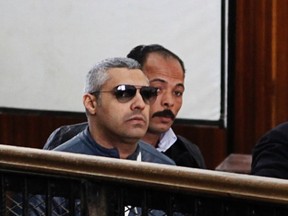 Al Jazeera journalist Mohamed Fahmy (in sunglasses) gets ready to speak before the judge at a court in Cairo, February 12, 2015. (REUTERS/Asmaa Waguih)