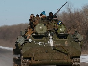 Members of the Ukrainian armed forces ride on a military vehicle near Debaltseve, eastern Ukraine, Feb. 17, 2015. (REUTERS/Gleb Garanich)
