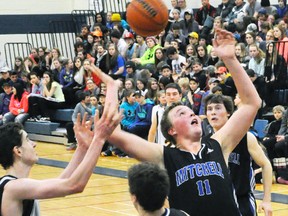 Josh Taylor of the MDHS senior boys basketball team reaches for the bouncing ball during quarter-final action against Stratford St. Mike's last Friday, Feb. 13 - a 45-40 Mitchell win. ANDY BADER/MITCHELL ADVOCATE