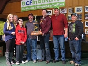 Members of the Richmond family presented the Bob Richmond Memorial trophy to the winning team of this year's All Ontario Farmers' Curling Bonspiel held in Wallaceburg. From left are Emma, Fay and Jake Richmond making the presentation to curlers Scott Lennox, Darren Jones, Doug Simpson and Kevin Bryan.