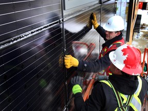 Mayor Don Iveson attach the last solar panel during the grand opening of the Net Zero office building in Edmonton, Alta. on Tuesday February 17, 2015. The Mosaic Centre for Conscious Community and Commerce is the most advanced energy and water efficient urban building to date. Perry Mah/Edmonton Sun/QMI Agency