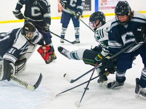 Catholic Central?s Dante Copps ties up Nathan Devereau of Mother Teresa after Crusaders goalie Kofi Ayinde gave up a rebound during the Spartans? 6-1 win Tuesday at Medway arena. (MIKE HENSEN, The London Free Press)