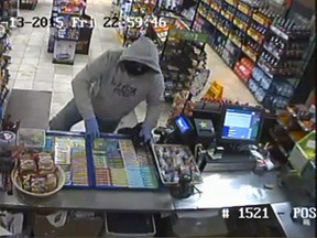 Sarnia Police are searching for a suspect in a robbery Friday at a Confederation Street convenience store. Police released a surveillance photo of the suspect jumping over the counter at the store. (Submitted photo)