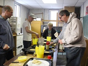 Volunteers (left to right) John Schilbe, Konrad Schilbe, (name not given) and Kevin Ball work like clockwork making pancakes.