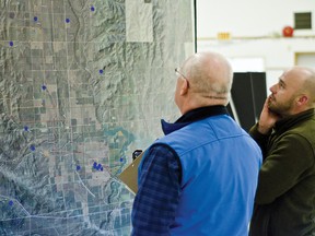 An AltaLink employee speaks with a community member during the transmission system developers round of open house sessions to unveil a ‘‘stakeholder suggested“ route. The forums for the Castle Rock Ridge to Chapel Rock proposal were held in Cowley on Feb. 10 and Lundbreck on Feb. 11. John Stoesser photos/QMI Agency.