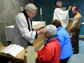 Rev Nick Wells, left, and Dean Kevin Dixon put the mark of the cross on parishioners at St. Paul's Cathedral during their Ash Wednesday service on Wednesday February 18, 2015. (Free Press file photo)