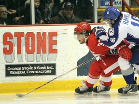 Soo Greyhounds forward Gabe Guertler (left) and Sudbury Wolves forward Jacob Harris chase the puck during first-period action Wednesday, Feb. 18, 2015 at Essar Centre in Sault Ste. Marie, Ont.