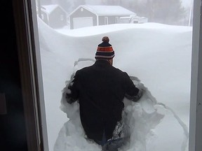 A New Brunswick man uploaded a video to YouTube showing the “nine-foot” snow bank that was built up in front of his door. ( YouTube screengrab )