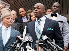 Defense attorney Rusty Hardin and NFL running back Adrian Peterson of the of the Minnesota Vikings address the media after Peterson plead "no contest" to a lesser misdemeanor charge of reckless assault on November 4, 2014 in Conroe, Texas. (Bob Levey/Getty Images/AFP)