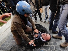 An Italian policeman detains a Feyenoord fan after clashes broke out prior to the start of the Europa League match between Roma and Feyenoord in Rome, February 19, 2015. (REUTERS/Yara Nardi)
