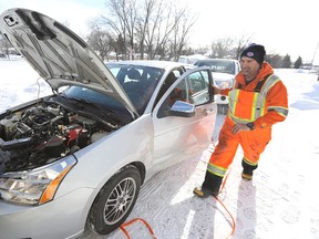 Doug Dauphinais of CAA Manitoba boosts a battery at a member's home in West Kildonan on Thu., Feb. 19, 2015.