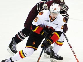 Trent Fox of the Belleville Bulls tries to elude the close checking of Josh Coyle of the Peterborough Petes during OHL action Thursday night in Peterborough. (Jessica Nyznik/Peterborough Examiner)