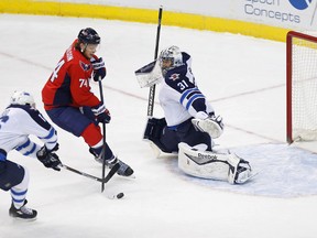 Winnipeg Jets goalie Ondrej Pavelec (31) makes a save on Washington Capitals defenseman John Carlson (74) as Jets left wing Andrew Ladd (16) defends in the first period at Verizon Center. The Capitals won 5-1. Mandatory Credit: Geoff Burke-USA TODAY Sports