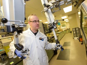 Dr. Michael Kovacs operates mechanical arms that control a pair of pincers inside a hot cell, which houses target equipment to make isotopes, in the cyclotron imaging lab at the Lawson Health Research Institute at St. Joseph's Hospital in London, Ont., on Feb. 19, 2015. (CRAIG GLOVER/QMI Agency)