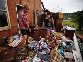 Melanie Cobb, right, and a relative retrieve a chest from her grandmother's damaged home after Cyclone Marcia hit the coastal town of Yeppoon in northeastern Australia, Feb. 20, 2015. (REUTERS/Jason Reed)