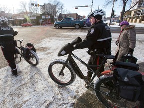 Edmonton Police Service Cst. Ryan Katchur (right) and Cst. Mike Zacharuk walk their fat bikes across 83 Avenue at 104 Street in Edmonton, Alta., on Wednesday, Feb. 4, 2014. The officers use the bicycles to patrol the Whyte Avenue area in the winter, bringing them into closer contact with residents. Fat bikes are a fast growing segment of the cycling industry, especially in winter cities such as the Capital City. Ian Kucerak/Edmonton Sun