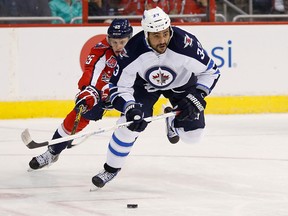 Winnipeg Jets defenseman Dustin Byfuglien (33) skates with the puck as Washington Capitals left wing Andre Burakovsky (65) chases in the second period at Verizon Center.