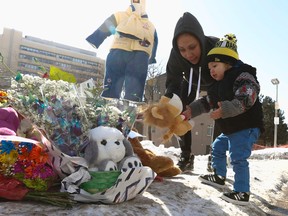 Mary and her son Shawn drop off a stuffed toy at the memorial for Elijah Marsh on Friday, Feb. 20, 2015. (JACK BOLAND/Toronto Sun)