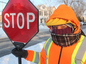 Crossing guard Diana Hughes bundles up in - 23 C temperatures for her shift on Rideau Street at Charles Street Friday morning. (Michael Lea/The Whig-Standard)