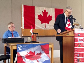 Bob Harper of Brockville, left, listens to Bill Fitsell of Kingston deliver his opening remarks during a debate about which city can claim to be the birthplace of the Canadian flag. (Elliot Ferguson/The Whig-Standard)