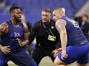 Offensive linemen Al Bond (left) of Memphis and Jon Feliciano of Miami participate in a blocking drill at yesterday’s combine. (GETTY IMAGES)