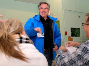 Alberta Premier Jim Prentice shows his MLA card for identification as he registers to vote in a ballot for the PC nomination in his home riding of Calgary-Mountain View   in Calgary, Alta., on Saturday February 21, 2015. Mike Drew/Calgary Sun/QMI Agency