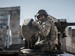 A Turkish soldier thumbs up on top of an army vehicle in a street of the Syrian town of Kobane, (aka Ain al-Arab) on February 22, 2015, during an operation to relieve the garrison guarding the Suleyman Shah mausoleum in northern Syria. AFP PHOTO / DEPO PHOTOS/MURSEL COBAN