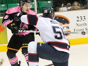 Belleville's Brett Gustavsen tries to bat the puck past Saginaw defender Keaton Middleton during Pink In The Rink OHL action Saturday night at Yardmen Arena. (Don Carr for The Intelligencer)