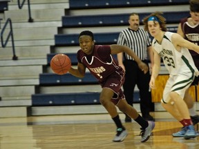 Kevin Toussaint of the Frontenac Falcons dribbles past Holy Cross's Tommy Pendergast during action in the high school junior basketball final. (Julien Gignac/For The Whig-Standard)