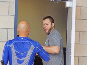 Veteran Blue Jays pitcher Mark Buehrle holds the door open as he renews acquaintances with teammate Ryan Goins on Sunday at spring training in Dunedin, Fla. (EDDIE MICHELS, photo)