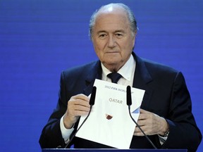 FIFA President Sepp Blatter holding up the name of Qatar during the official announcement of the 2022 World Cup host country at the FIFA headquarters in Zurich. (AFP PHOTO / PHILIPPE DESMAZES)