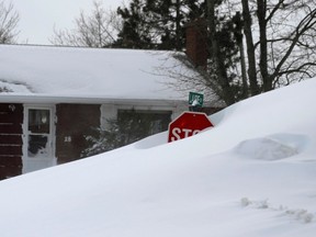 A snow bank conceals a stop sign after a winter storm hit Charlottetown, P.E.I., Feb. 16, 2015.  REUTERS/Nathan Rochford