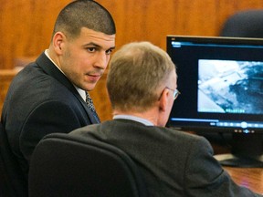 Former NFL player Aaron Hernandez (L) looks at his attorney as security footage is seen on a monitor during his murder trial at the Bristol County Superior Court in Fall River, Massachusetts February 20, 2015.   REUTERS/Dominick Reuter